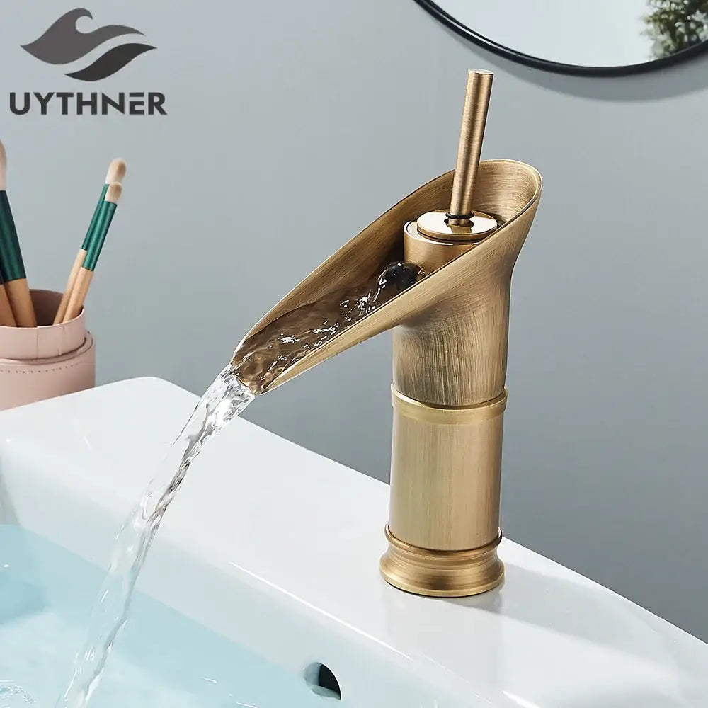 Modern antique brass waterfall faucet with brass finish and matte black accents for bathroom sink use