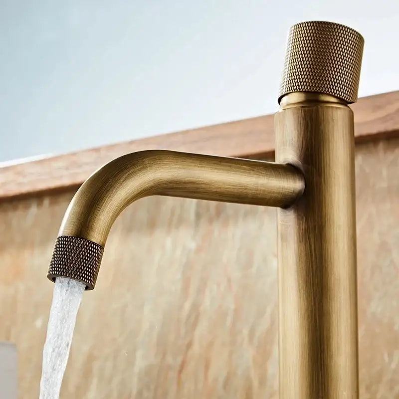 Antique bronze modern bathroom faucet with brass finish, textured knurled handles, and sleek curved spout for cold water use