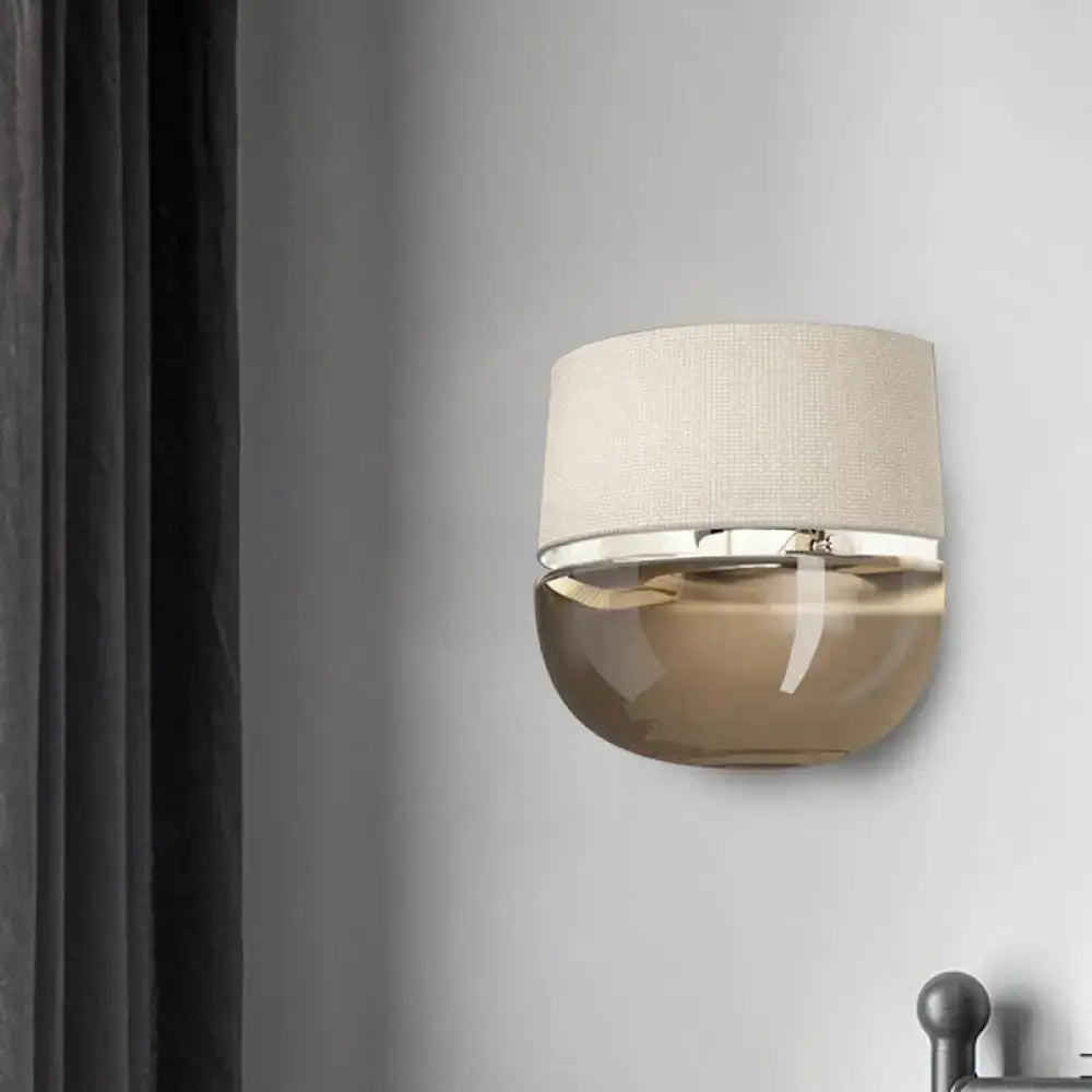 Modern arched beige wall sconce with tan glass curved base and polished chrome trim for bedroom lighting