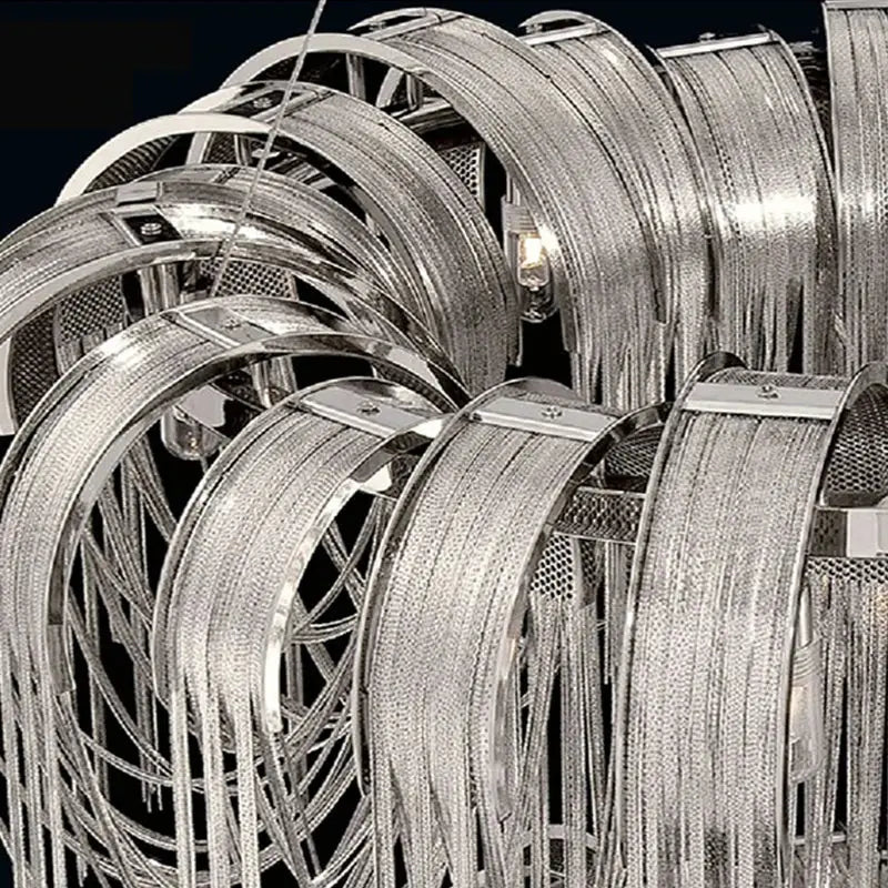 Silver metallic modern arched chandelier with intricate overlapping circular rings and dangling aluminum chain mesh