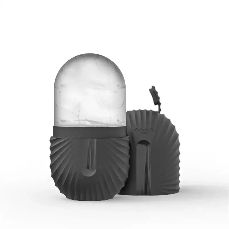 Black textured ice cube tray with translucent dome lid featuring marble-like veining for facial roller massager storage