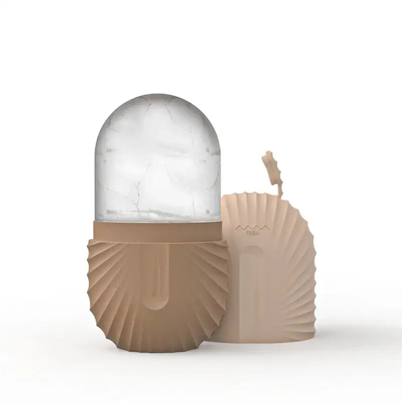 Beige seashell-shaped silicone ice bucket with clear marble-patterned dome lid for ice cube storage and facial roller massager use