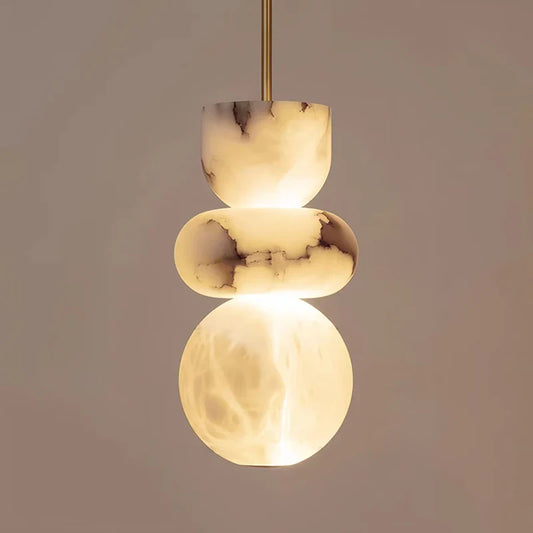 A modern pendant light with three stacked warm-toned alabaster orbs featuring natural veining for indoor ceiling chandelier decor