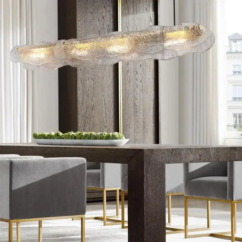 A modern translucent glass dining table chandelier with textured organic shape and warm led luxury lighting decorbites art glass