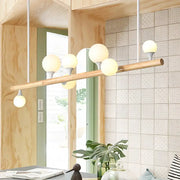 Modern asian wood hanging ceiling light with natural wood bar and five frosted glass globe bulbs for dining room