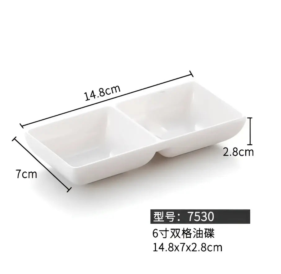 White ceramic two-compartment serving dish with minimalist design paired with decorbites black melamine dipping sauce bowls