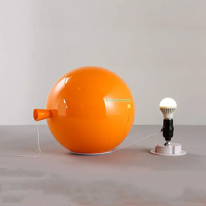 Modern balloon wall light featuring a vibrant orange glossy spherical lamp with a small nozzle side protrusion
