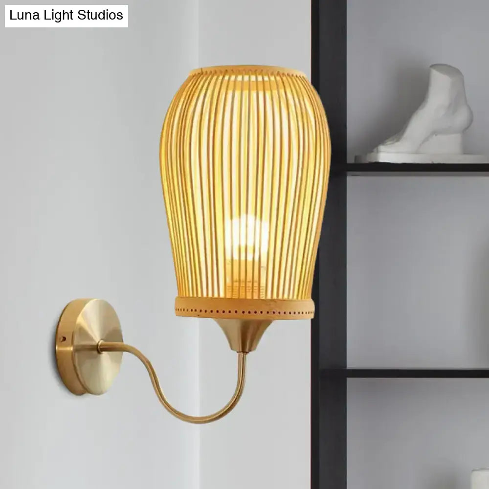 Modern bamboo cage wall sconce with golden bamboo slats and brass-finished metal gooseneck arm for bedroom lighting
