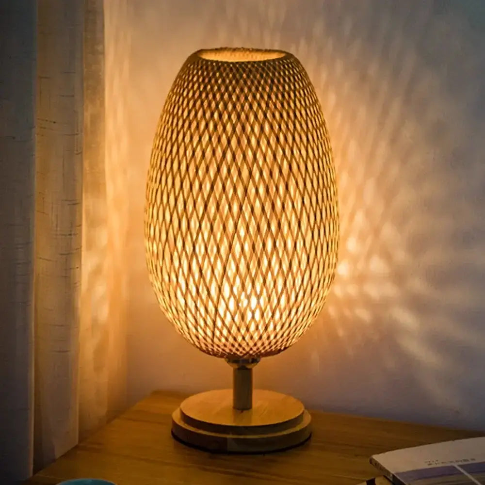 Warm-toned bamboo weave table lamp with an egg-shaped woven shade and wooden base for modern bedroom use