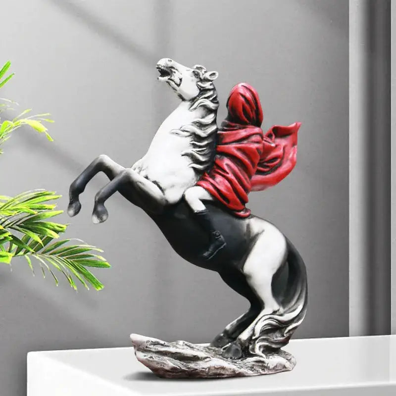 Modern banksy red knight statue featuring a black and white resin horse with a rider in flowing red fabric on a textured base