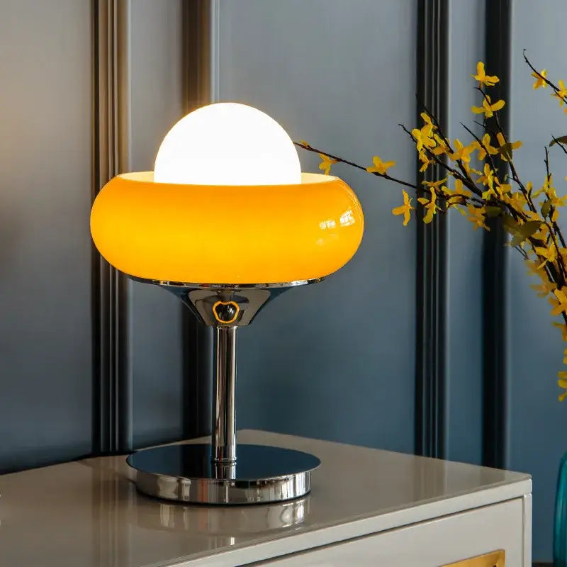 A sleek guzzini modern bauhaus table lamp with vibrant orange translucent glass dome and polished chrome base for decorbites