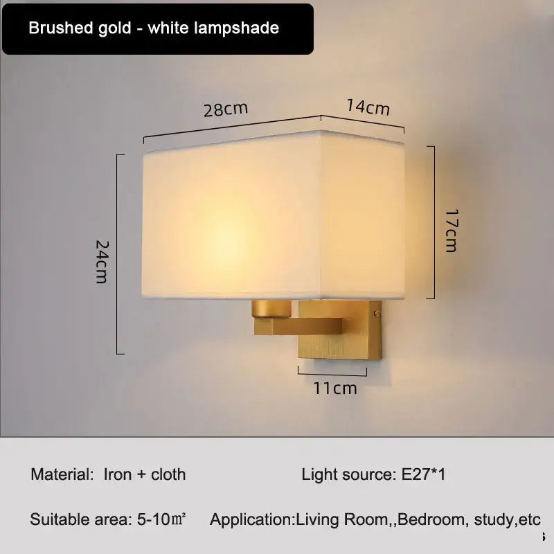 Brushed gold wall lamp with a rectangular white fabric shade for an elegant bedroom wall lamp setup