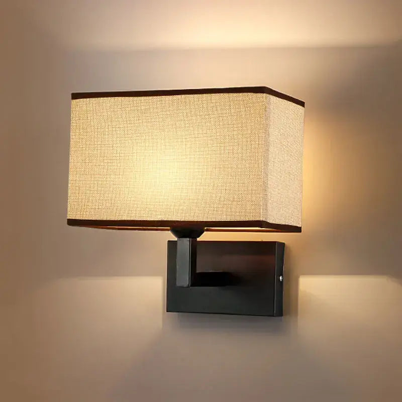 Modern beige and brown hotel fabric wall lamp with rectangular beige fabric shade and dark brown trim on black metal fixture