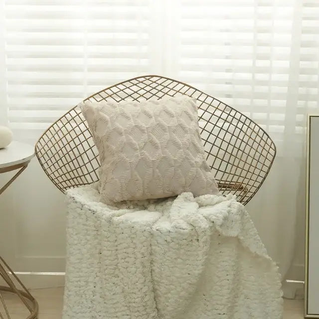 Cream-colored textured knit cushion cover with modern beige diamond solid embroidery on a wireframe chair