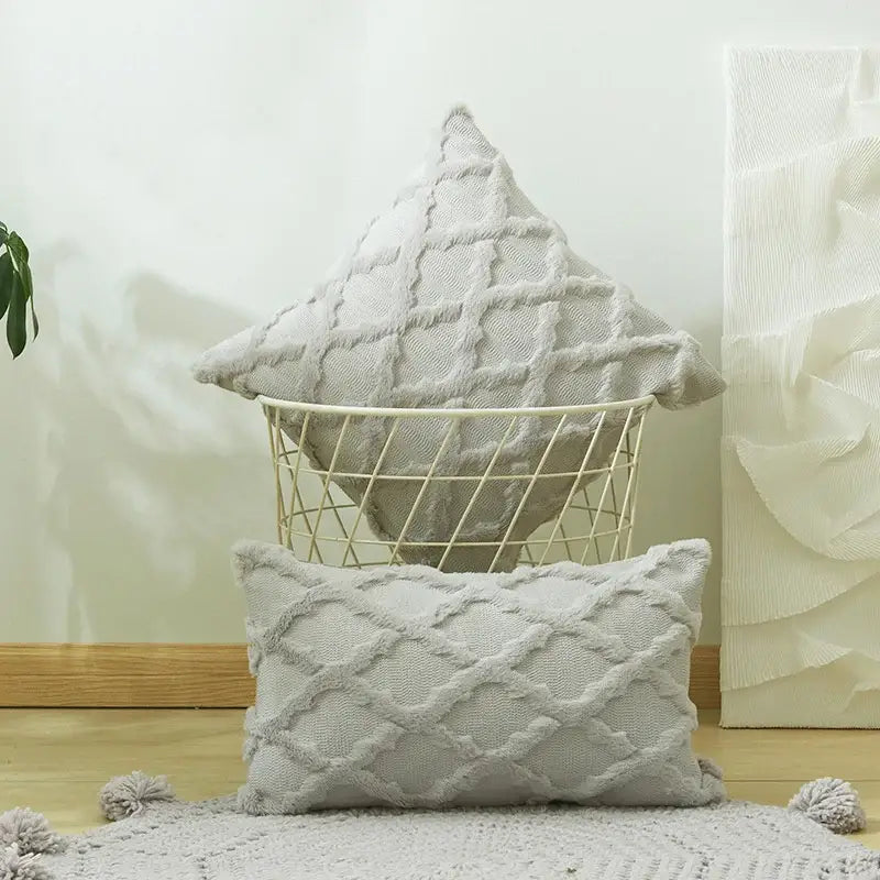 A soft light gray cushion cover with diamond solid embroidery and pom-pom accents for modern living room decor