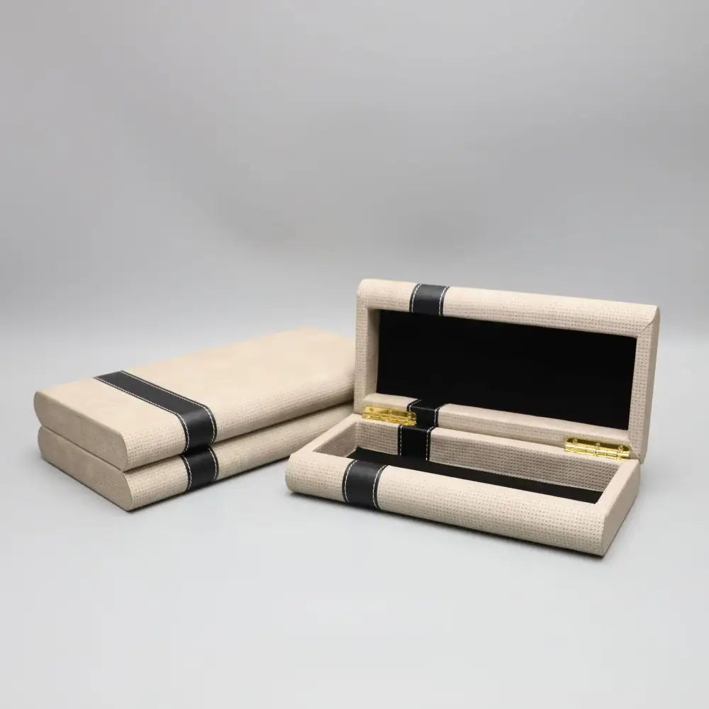 Modern beige geometric jewelry storage box with textured finish black leather straps and gold-tone hardware for decorbites storage box