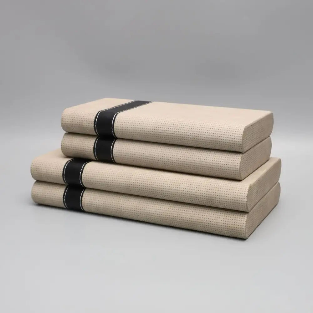 Stack of four beige textured books with black ribbon bands beside decorbites geometric jewelry storage box for bedroom organizer