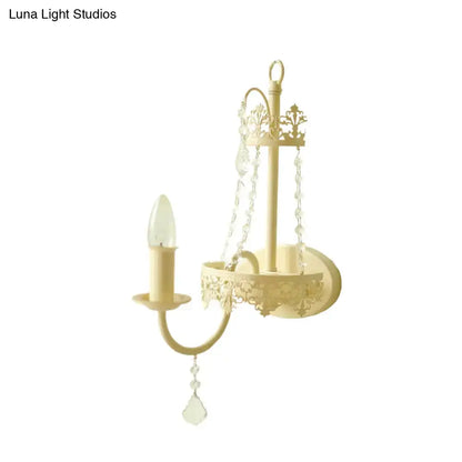 Cream-colored wrought iron wall sconce with ornate scrollwork and crystal beads modern beige 15 inch fixture