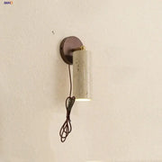 Modern beige stone and bronze cylindrical wall light fixture with brass accent for bedroom lighting