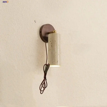 Modern beige stone and bronze cylindrical wall light fixture with brass accent for bedroom lighting