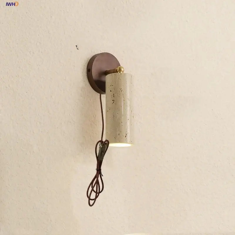 Modern beige stone and bronze cylindrical wall light fixture with brass accent for bedroom lighting