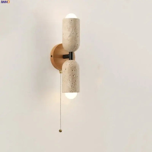 Modern beige stone and wood wall light fixture with textured concrete sconce and black metal accents for bedroom use