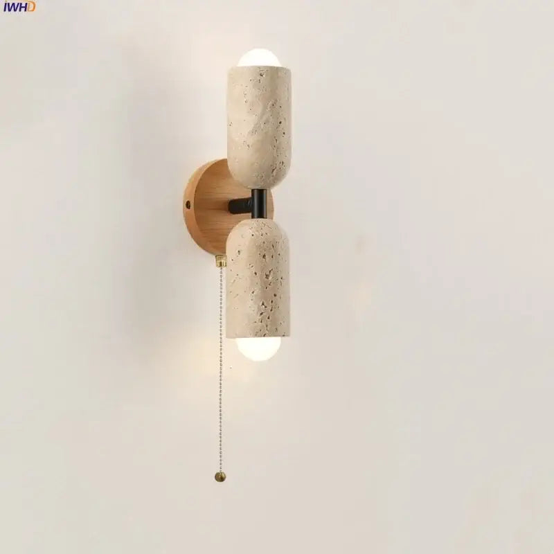 Modern beige stone and wood wall light fixture with textured concrete sconce and black metal accents for bedroom use