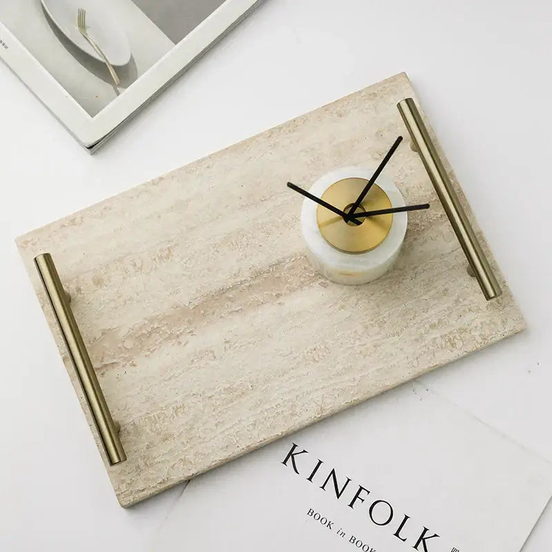 Beige travertine stone tray with gold-toned metal handles and small white marble clock for modern decorbites beige travertine decor