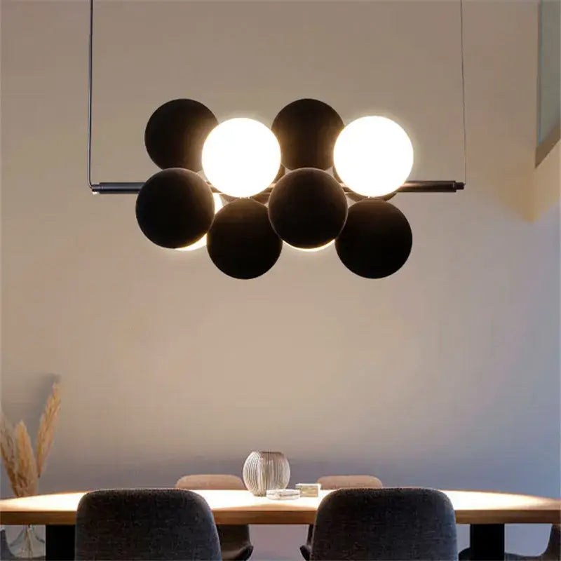 Modern beige and white decorbites abstracta pendant lamp with black spherical cluster and glowing white bulbs for dining room decor