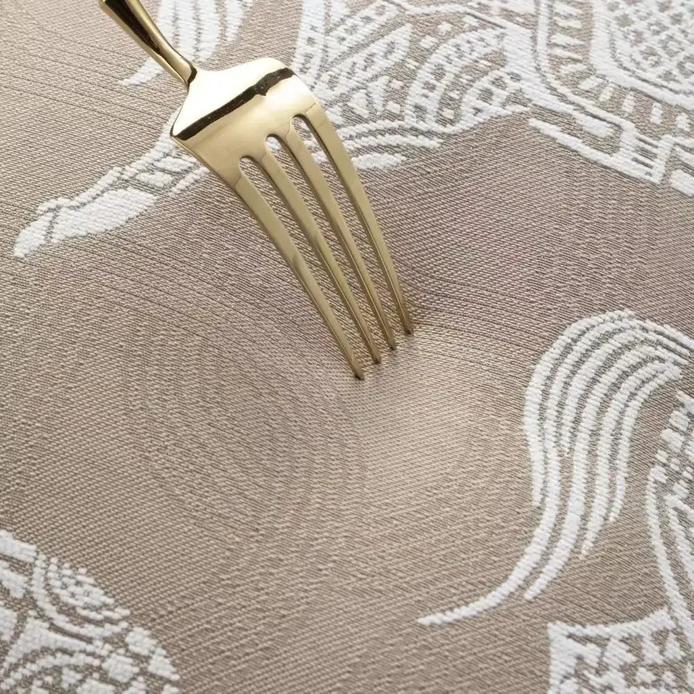 A gold-toned fork on a beige placemat with white embroidery beside a modern beige and white leaping cat jacquard cushion cover decorbites geometric jacquard cushion covers