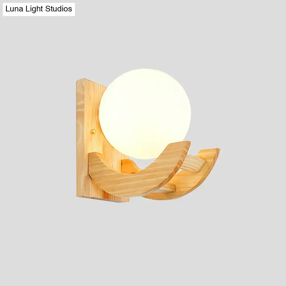 Modern beige wood sconce light fixture with warm frosted spherical glass shade and curved natural wood arms wall lamp