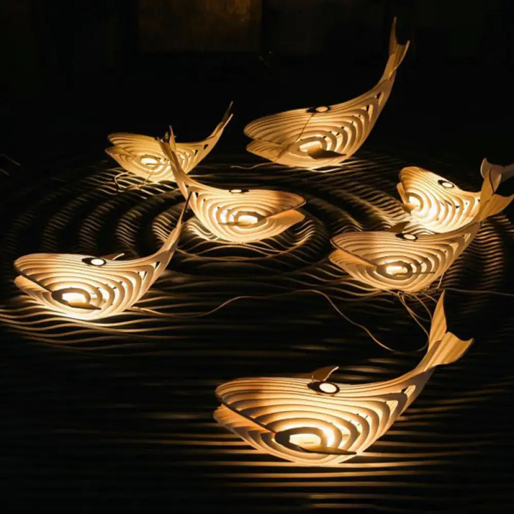 Modern beige wooden whale kids pendant light with warmly glowing layered fish lantern design for bedroom hanging lamp