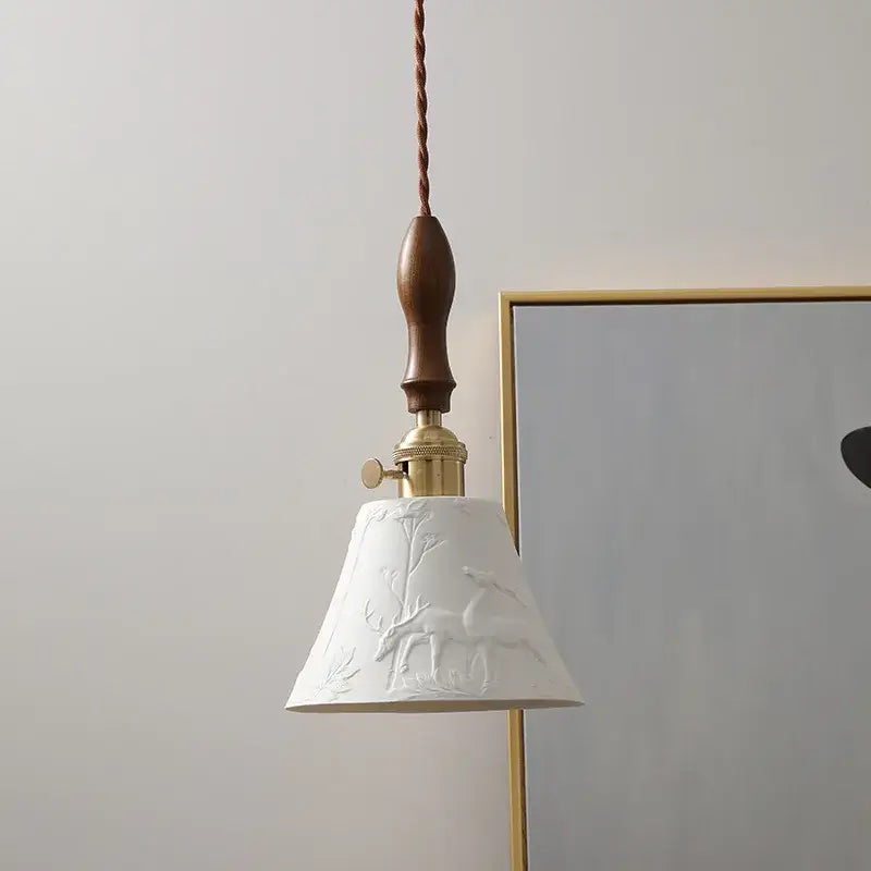 Modern bell ceramic led pendant light featuring white ceramic with embossed deer and tree design and dark wood handle