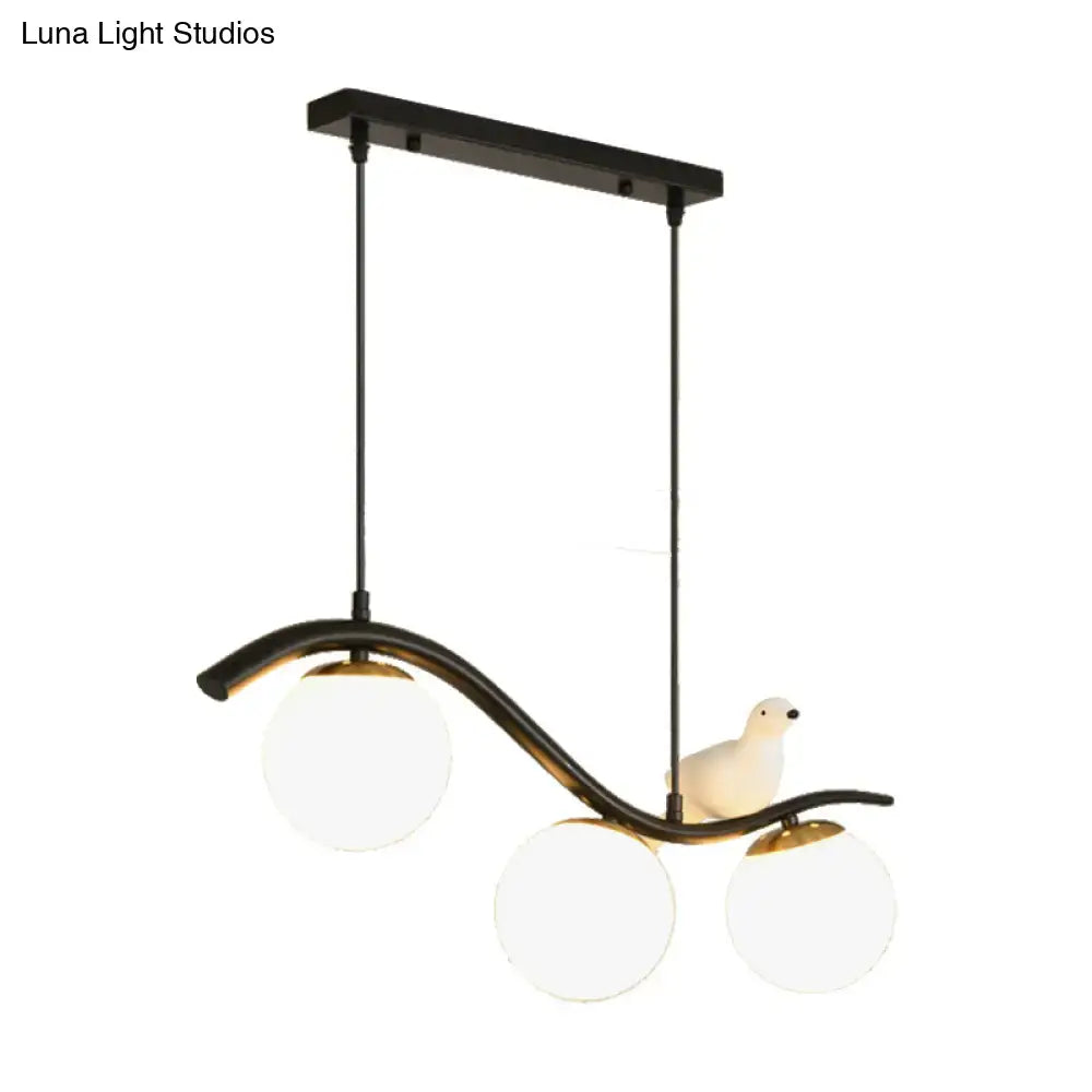 DecorBites modern 3-head black metal pendant light with clear white ball shade hanging and white ceramic pigeon decor