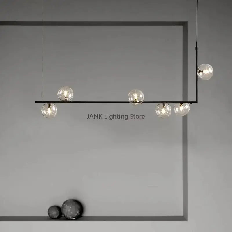 Modern black metal pendant light with five clear glass globe bulbs featuring double glass shade design for dining room