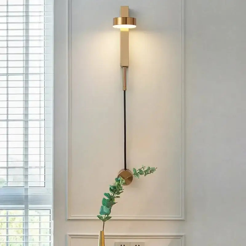 Modern gold-toned wall lamp with cylindrical adjustable led fixture and black cord for decorbites adjustable led wall lighting