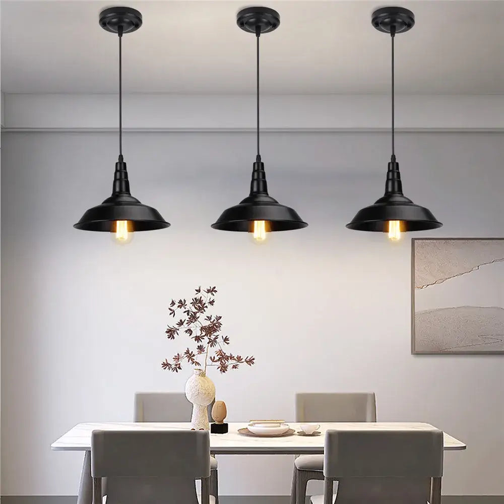 Three black aluminium modern pendant lights with exposed bulbs hang above a dining table for decorbites black aluminium decor