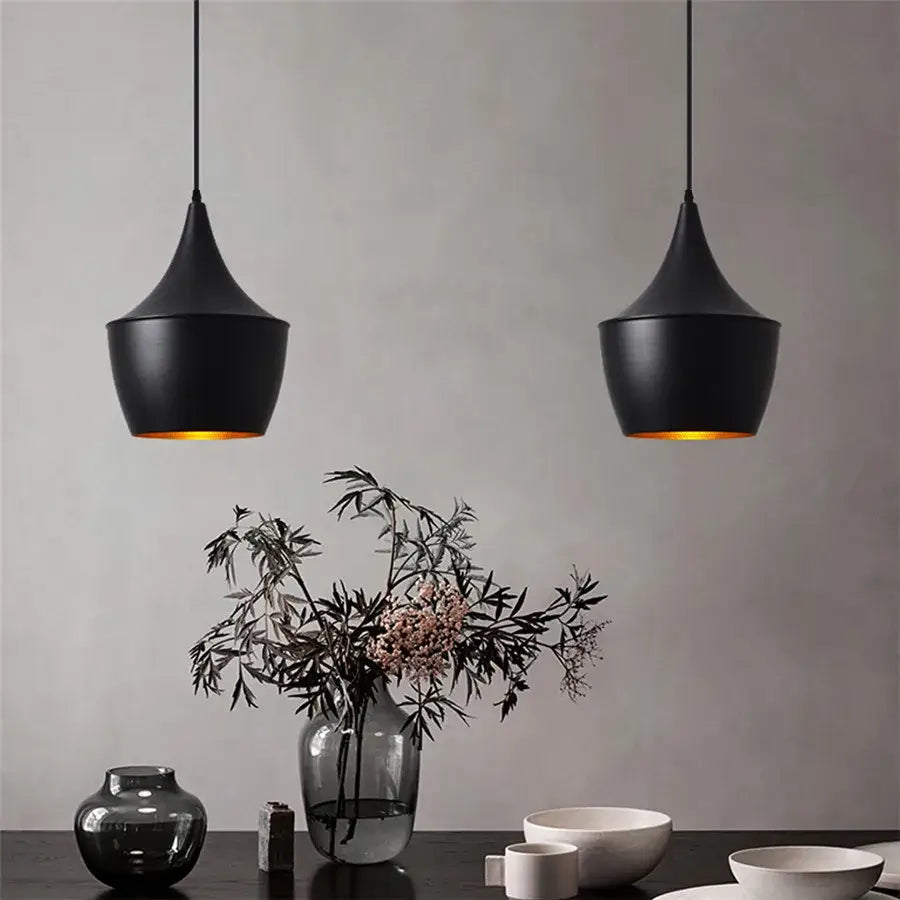 Two sleek black aluminium modern pendant lights with matte finish and warm golden glow for dining room decorbites decor