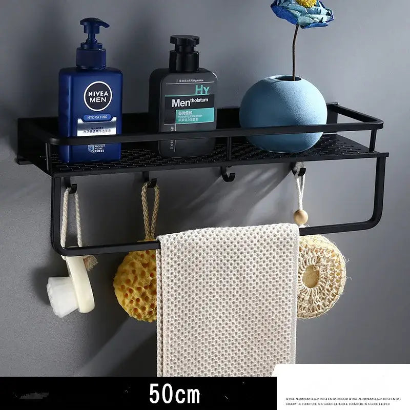 Modern black aluminum bathroom shelf with towel bar and mesh grid holding towel sponge loofah and soap dispenser