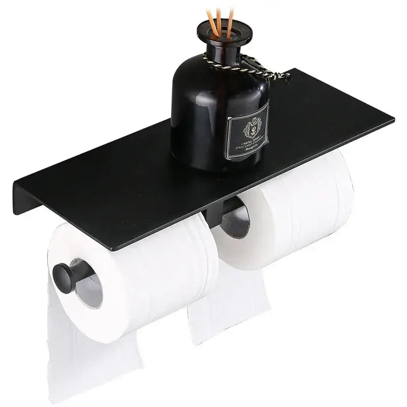 Modern black aluminum toilet paper holder with shelf featuring a dark glass diffuser bottle for bathroom use