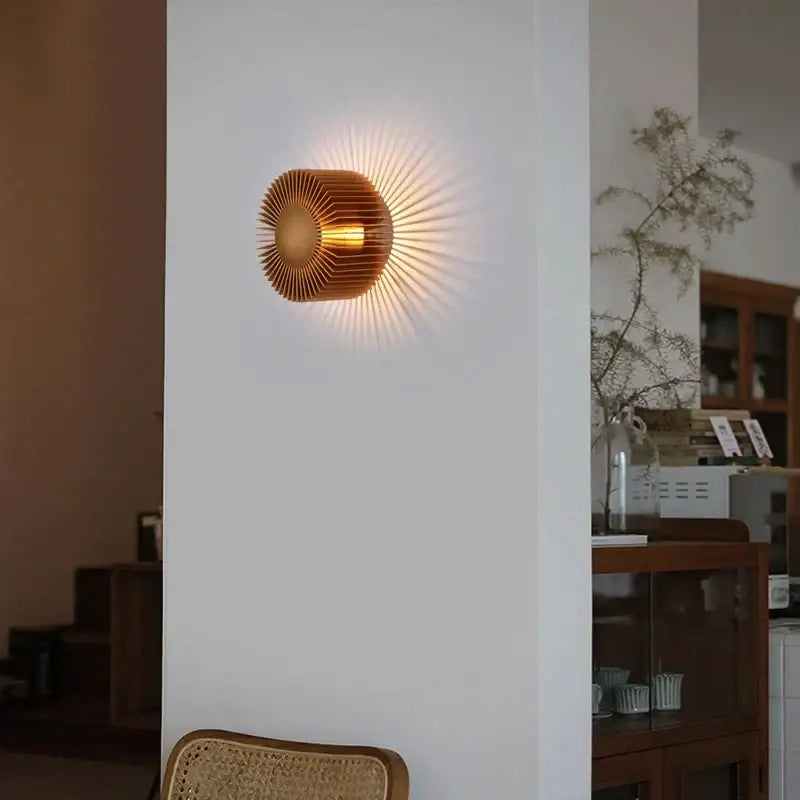 Golden sunburst wall sconce with radiating metallic rays in elegant black aluminum wall sconce for living room use