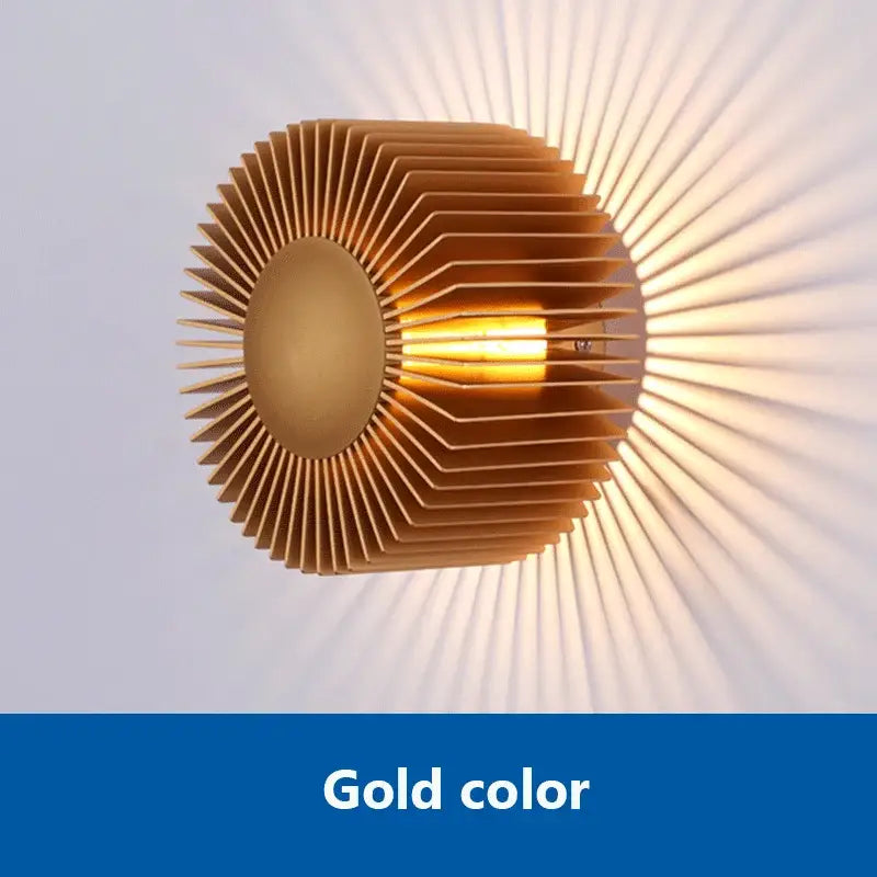 Gold-colored elegant aluminum wall sconce with sunburst metallic slats for modern living room lighting