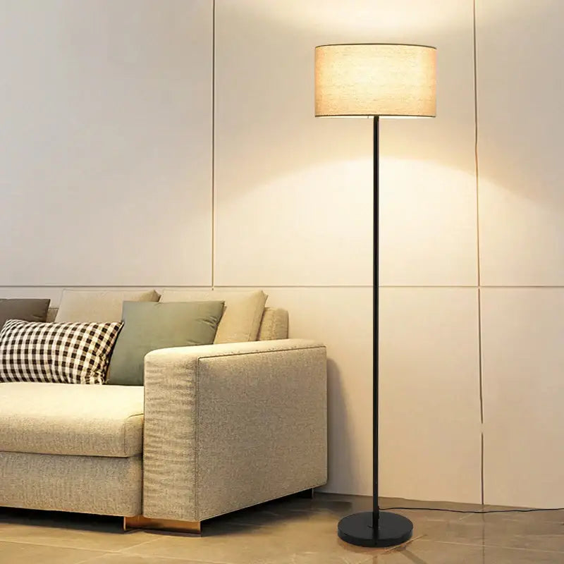 Modern black and beige led vertical floor lamp with cylindrical fabric shade for living room use