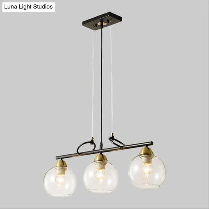 Decorbites contemporary 3-bulb pendant light with black metal, smoke gray glass globes, and brass accents for hall island