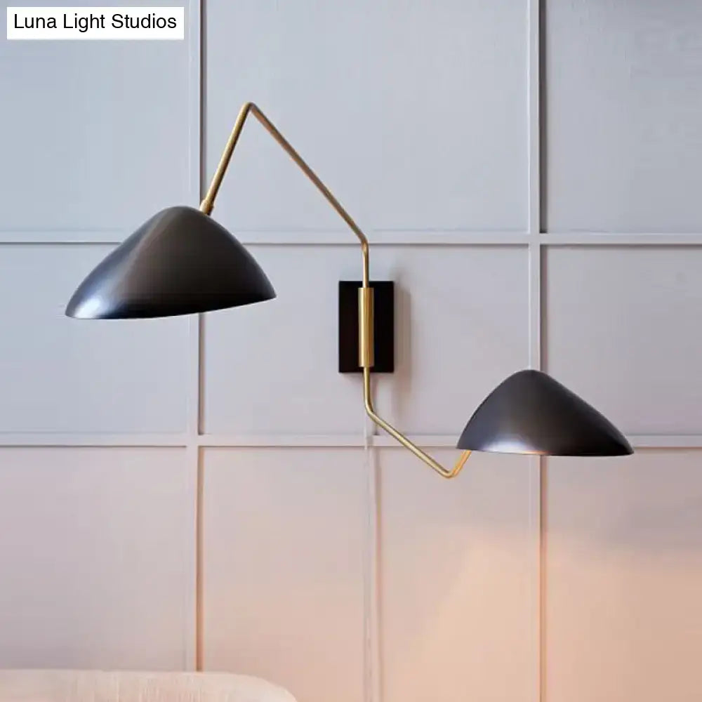 Modern black and brass metal duckbill reading wall sconce with matte black conical shades and articulated arms for bedroom use