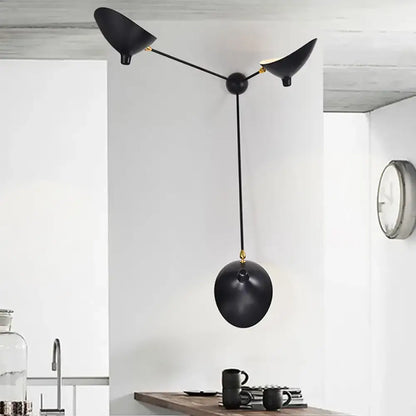 Modern black and brass wall lamp with three angular metallic shade fixtures and central spherical element for living room
