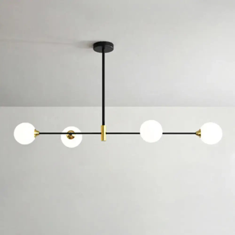 Modern black and brass metal island pendant with four frosted glass globe bulbs and adjustable chain cord length chandelier