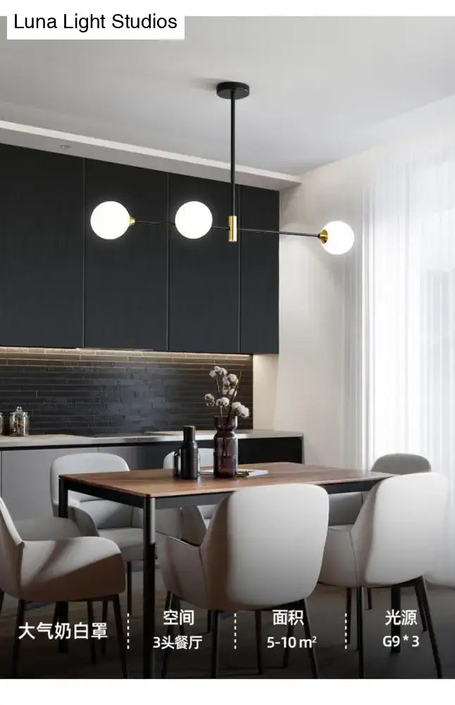 Modern black metal island pendant light with brass accents and three spherical bulbs for dining room chandelier use