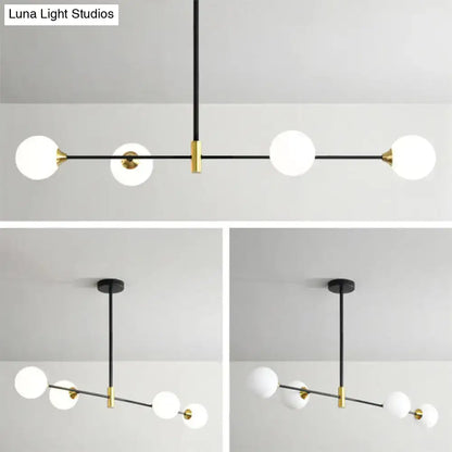 Modern black and brass metal island pendant with frosted glass globe bulbs and adjustable chain cord length for dining room