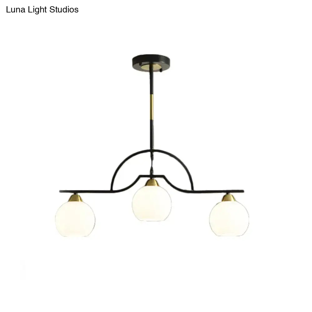 Black metal chandelier with three cream clear glass globe shades and gold accents in black finish pendant lamp design